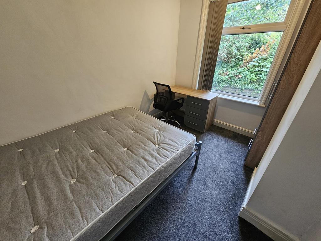 A cozy single bedroom with a comfortable bed po...