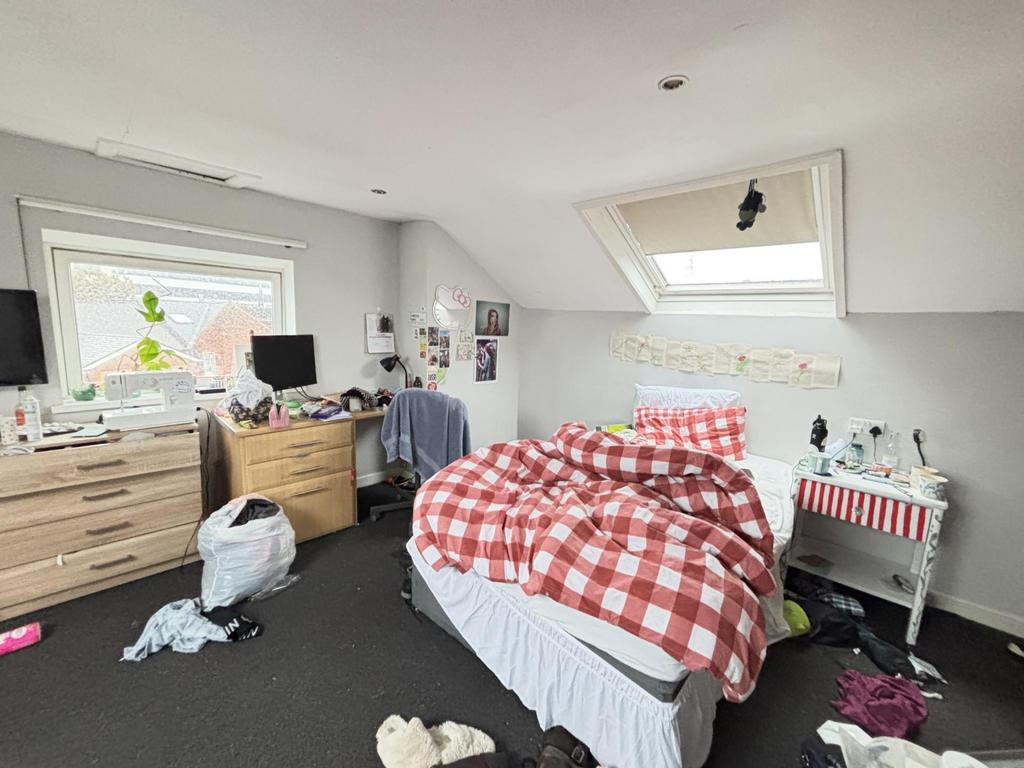 A cozy bedroom with a large window letting in n...
