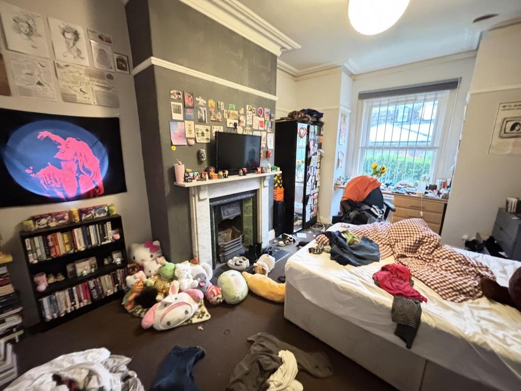 A cozy bedroom featuring a large bed with a var...