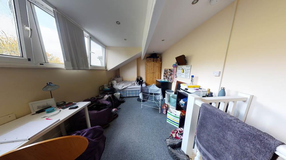 A bright, cozy bedroom with a large window prov...