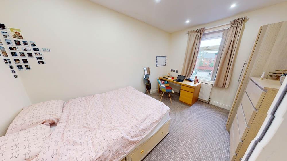 Bright and welcoming double bedroom featuring a...