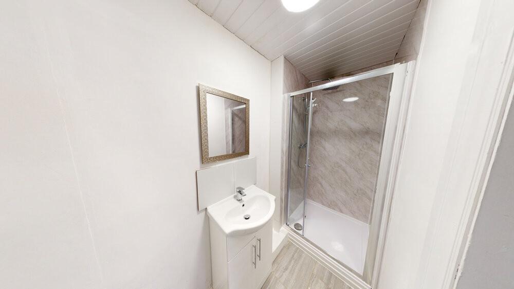 A clean, bright bathroom with a shower enclosur...