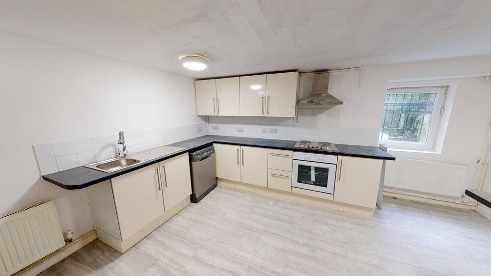 Bright, modern kitchen with cream cabinetry, in...