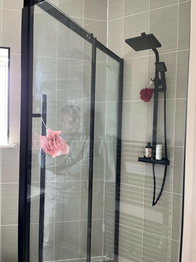 A modern bathroom shower area featuring a sleek...