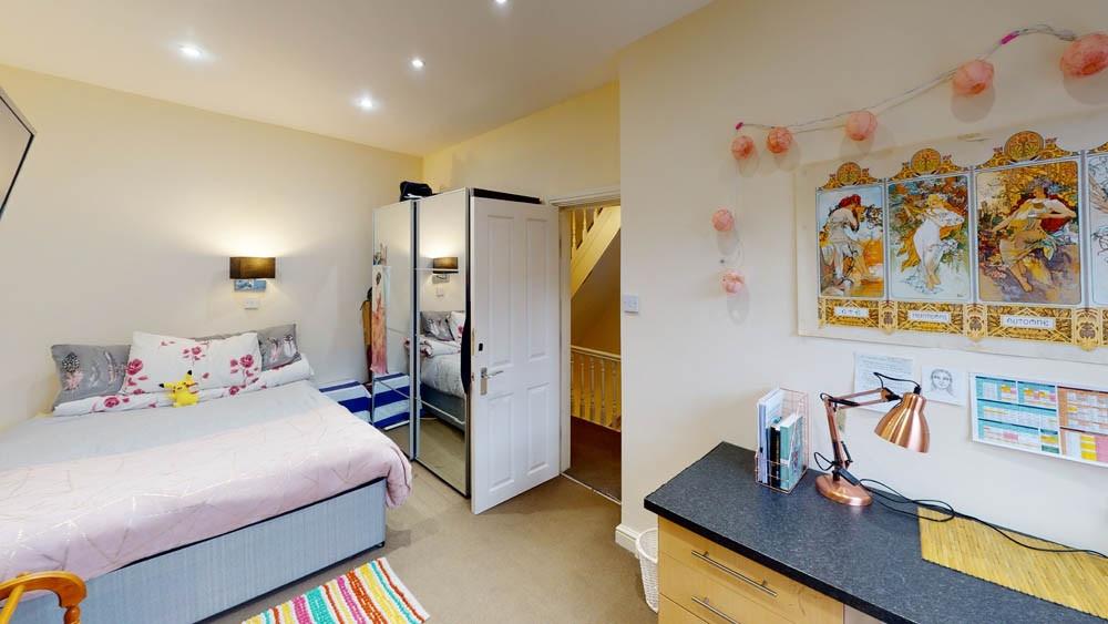 A bright and welcoming bedroom featuring a comf...