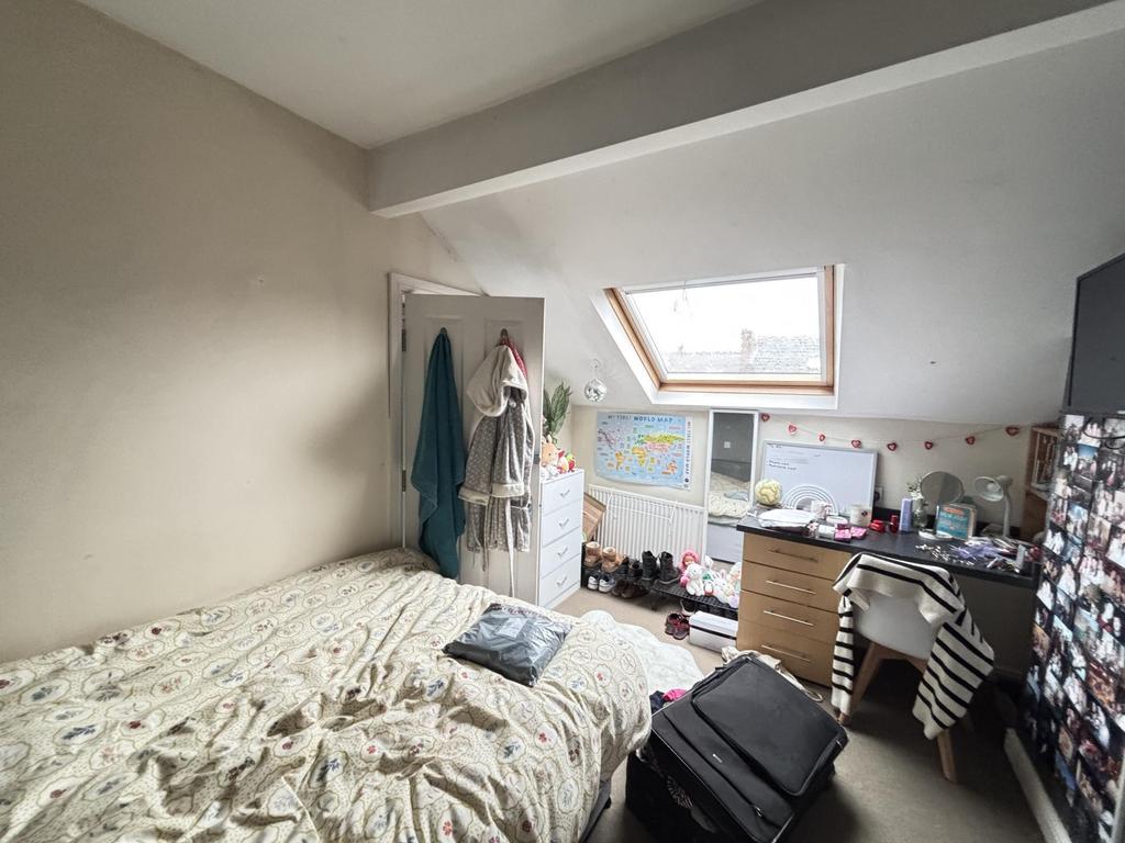 A cozy bedroom featuring a comfy bed, a skyligh...