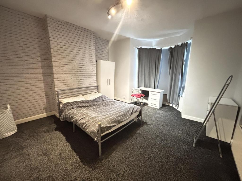 A spacious bedroom featuring a double bed, larg...