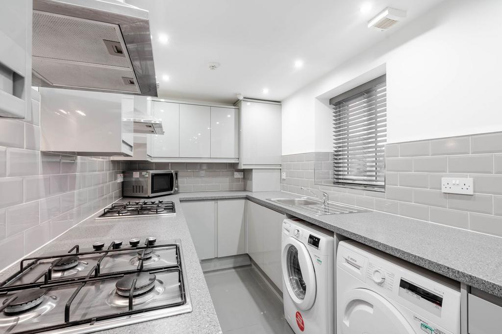 Modern, bright kitchen with sleek white cabinet...