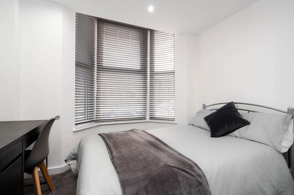 A bright and inviting bedroom featuring a large...