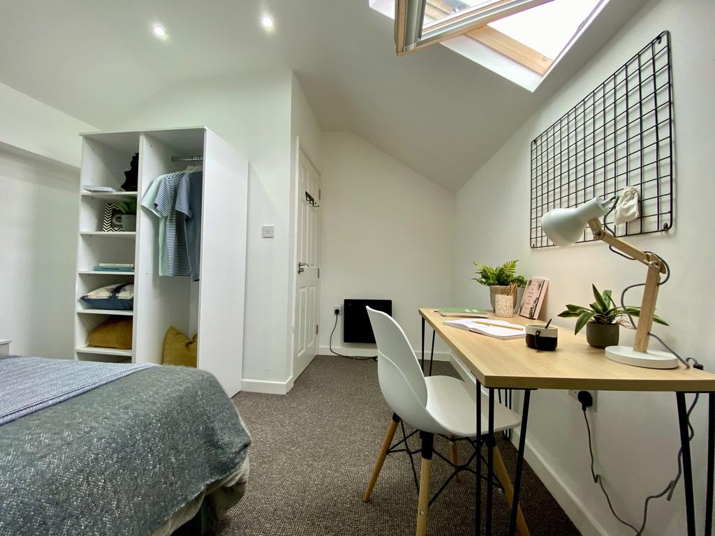A spacious and bright double bedroom featuring ...