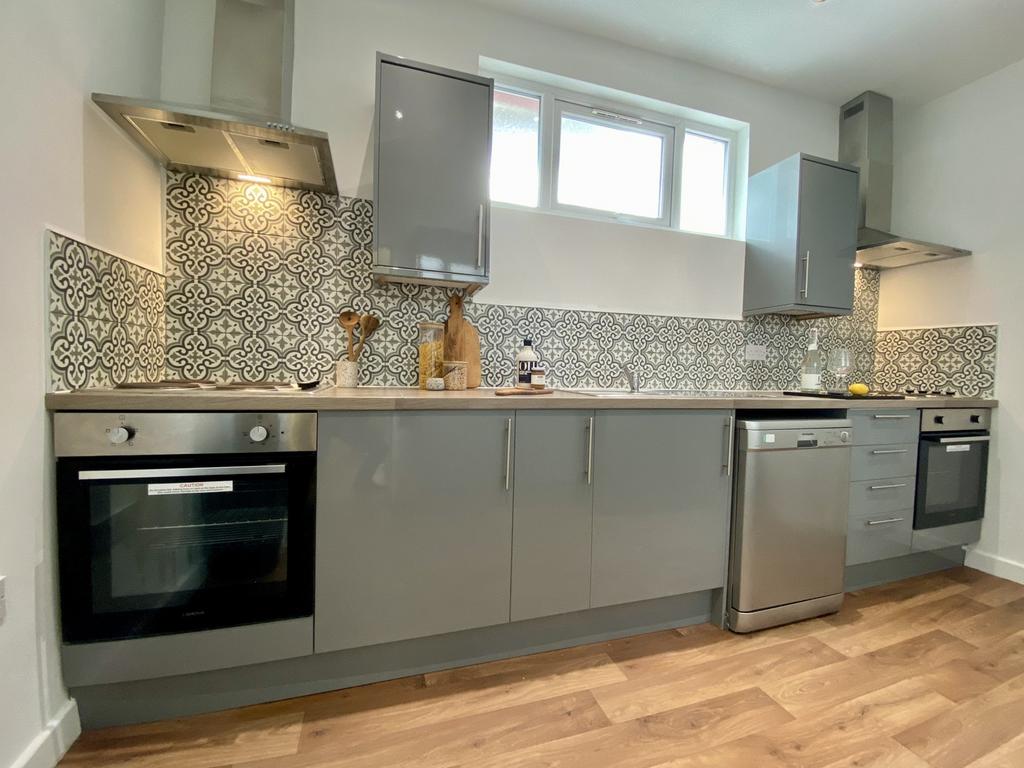 A modern and stylish kitchen featuring sleek gr...