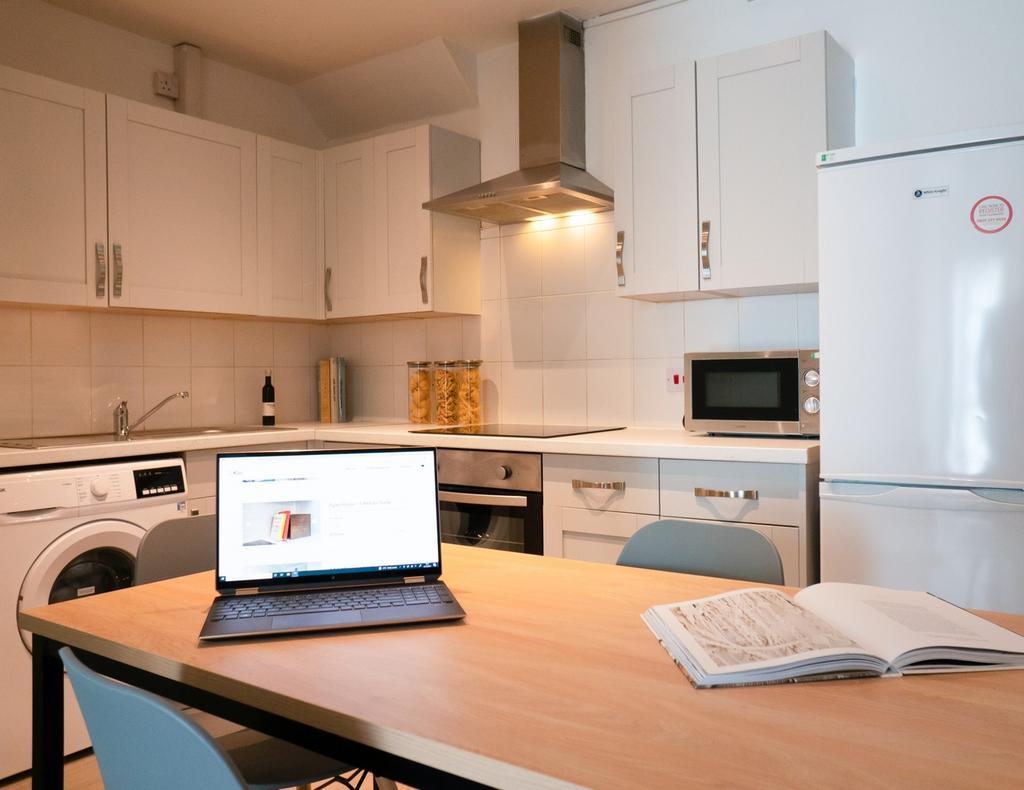 A bright and modern kitchenette with ample stor...
