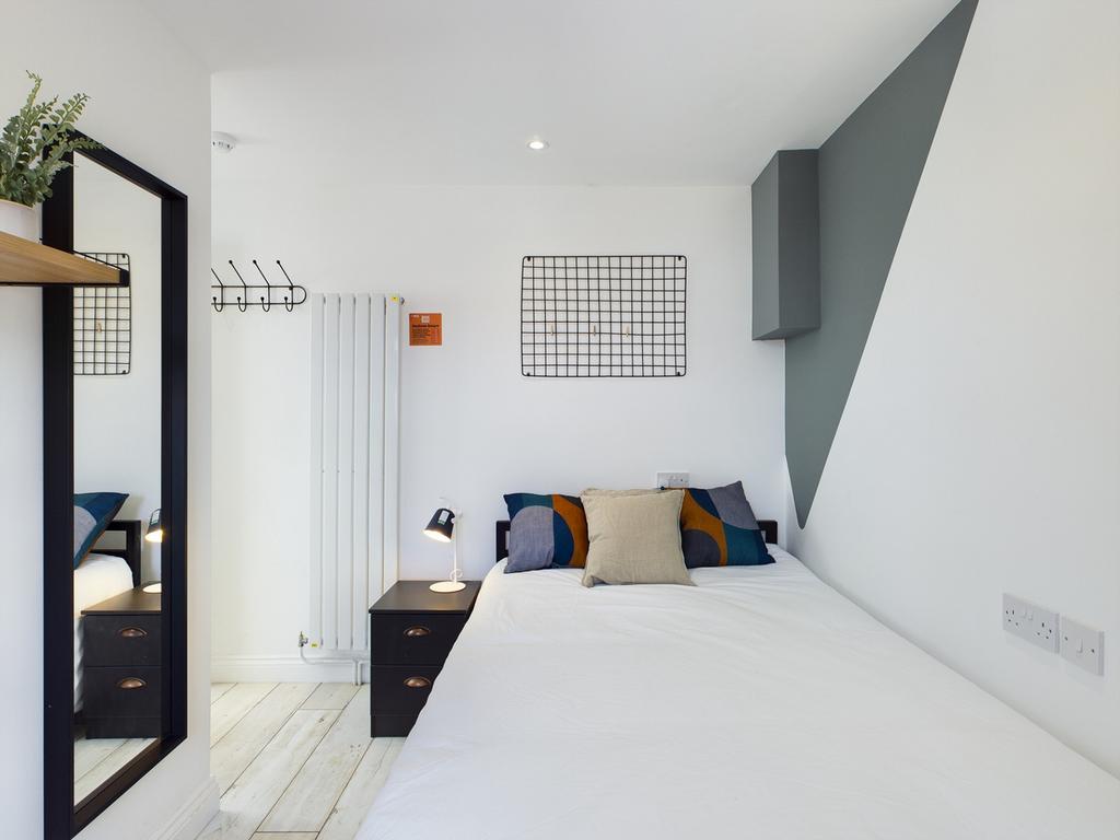 A bright and stylish double bedroom featuring m...
