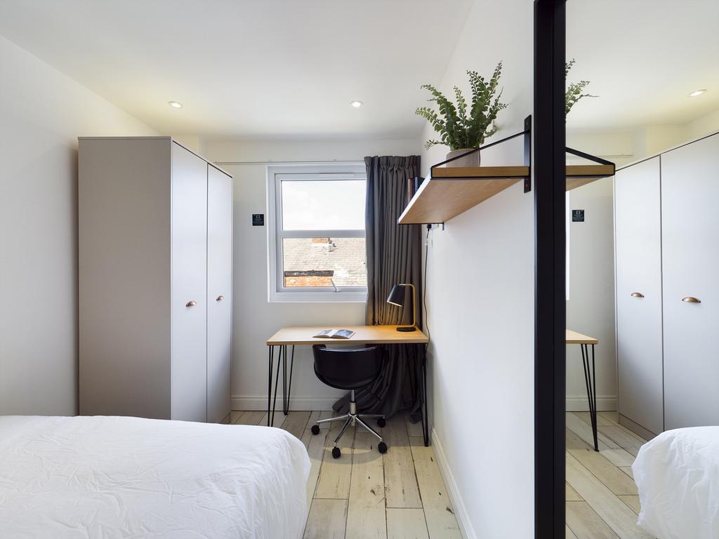A bright and clean double bedroom featuring a w...