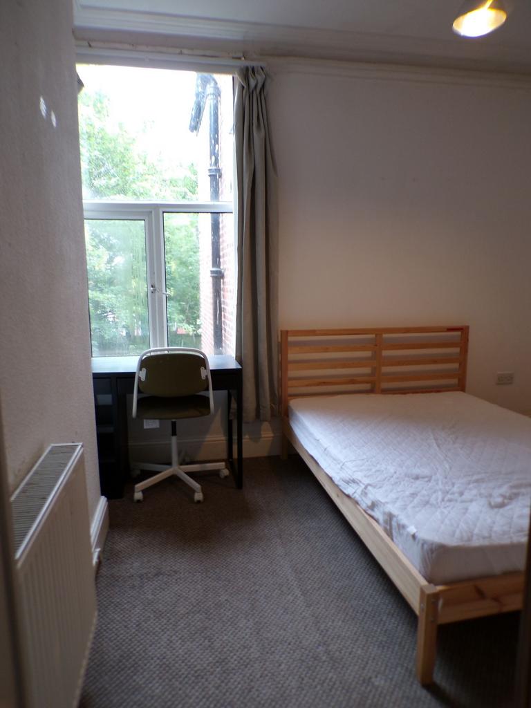 Bright bedroom with a large window, simple wood...