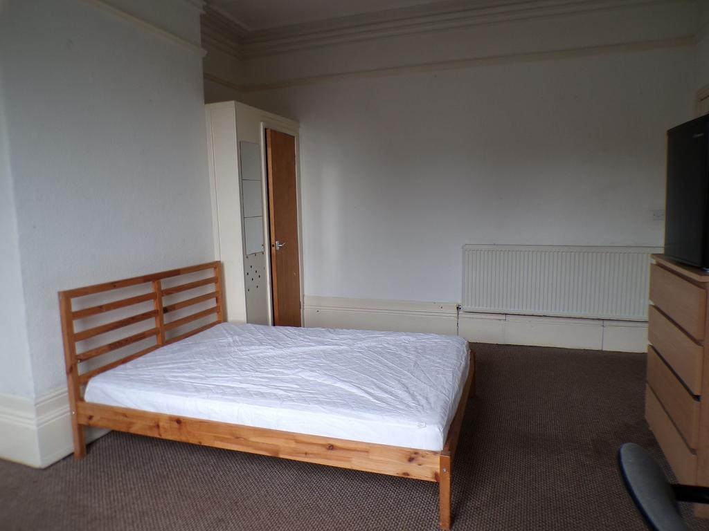 Bright, simply furnished bedroom with a wooden ...