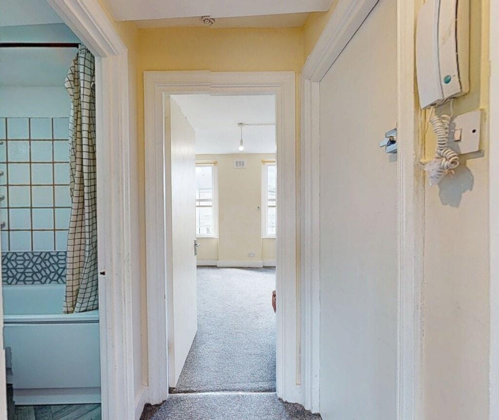 A bright hallway with neutral walls and carpete...