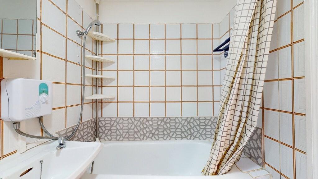 Bright and clean bathroom suite featuring a whi...