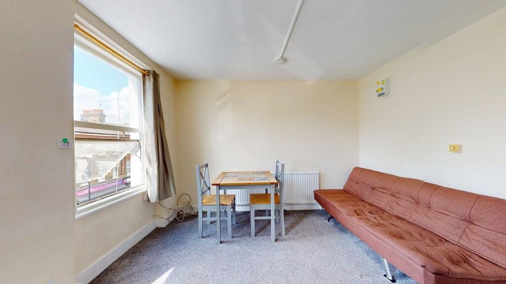 A bright living room featuring a large window w...