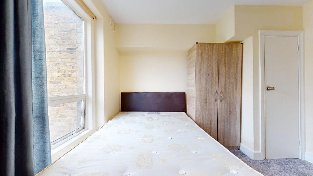 A bright double bedroom featuring a comfortable...