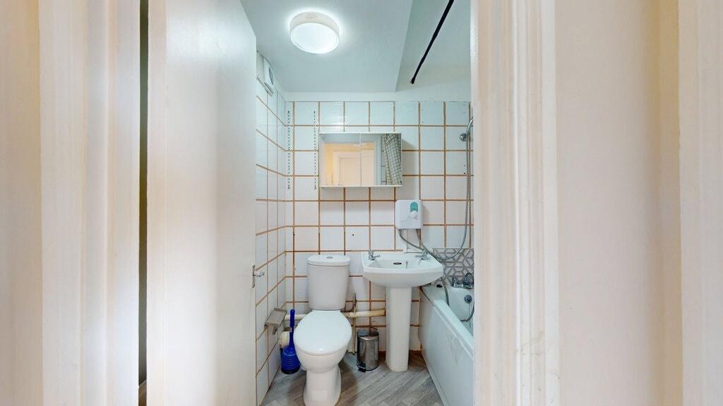 Bright and clean bathroom suite featuring a ful...