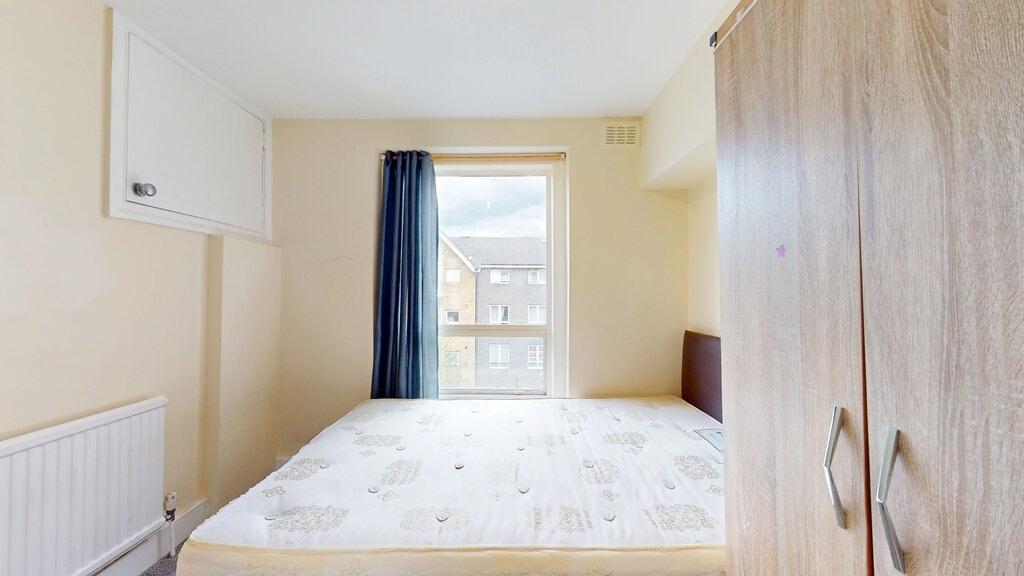 Bright double bedroom featuring a large window ...