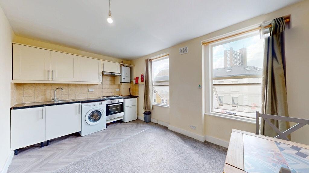 Bright and tidy kitchen area featuring modern a...