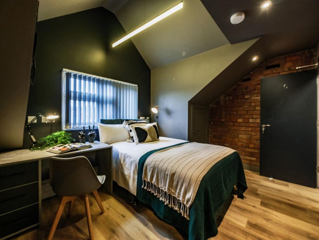 A stylish and modern master bedroom featuring a...