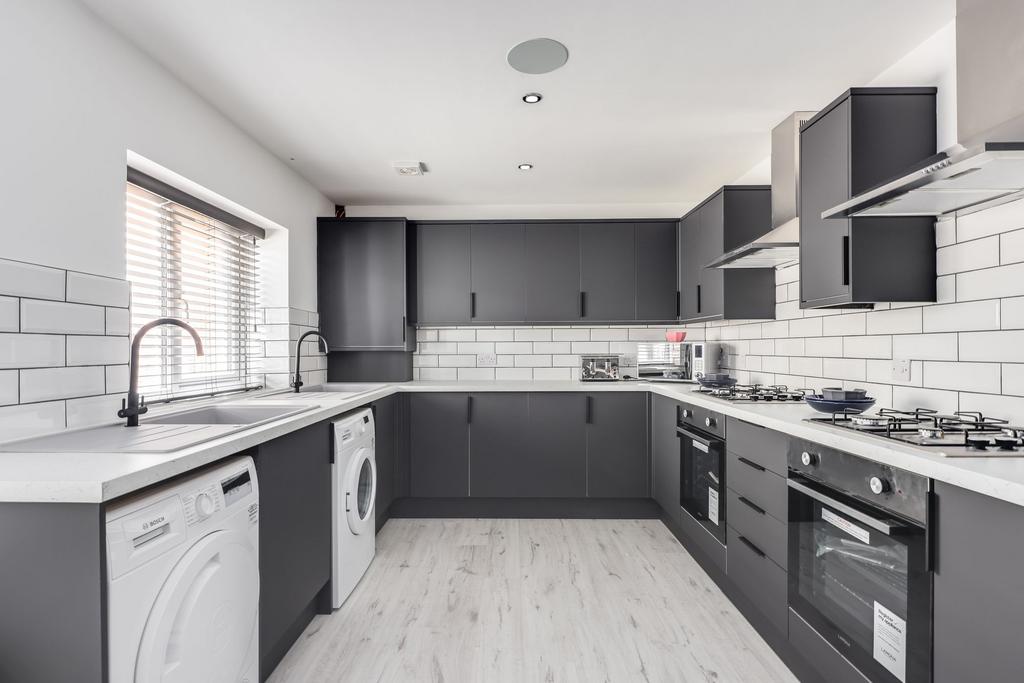 Modern kitchen with sleek dark cabinetry, brigh...