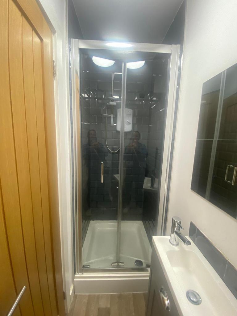 Modern bathroom with a framed glass shower encl...
