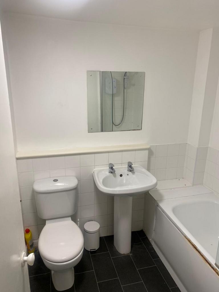 A clean, functional bathroom featuring a toilet...