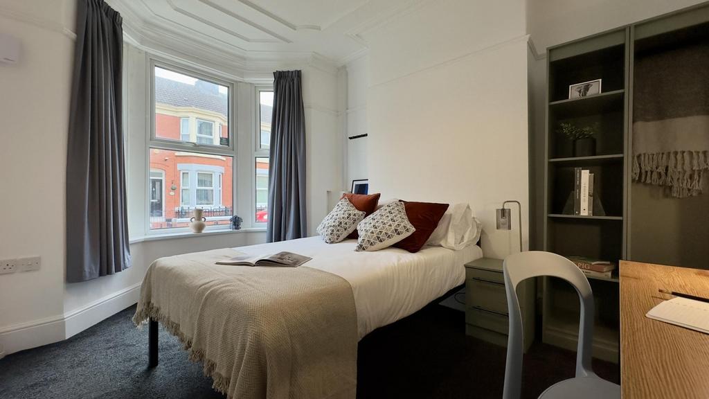A bright and inviting double bedroom with styli...
