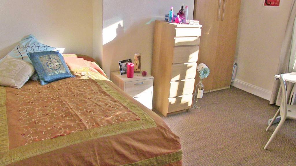 Bright, simply furnished bedroom with a comfort...