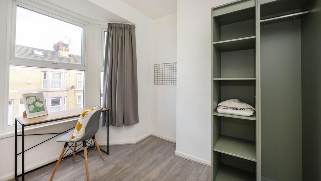A bright and tidy double bedroom featuring a st...