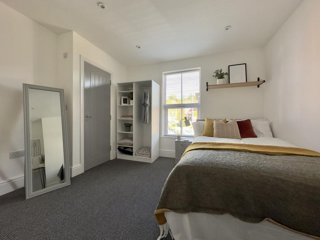 A bright and inviting double bedroom with a sty...
