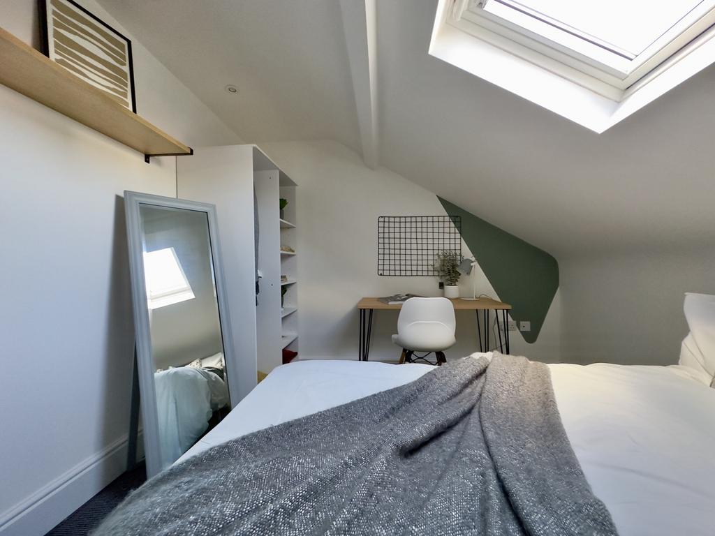 A bright and tidy double bedroom featuring a co...