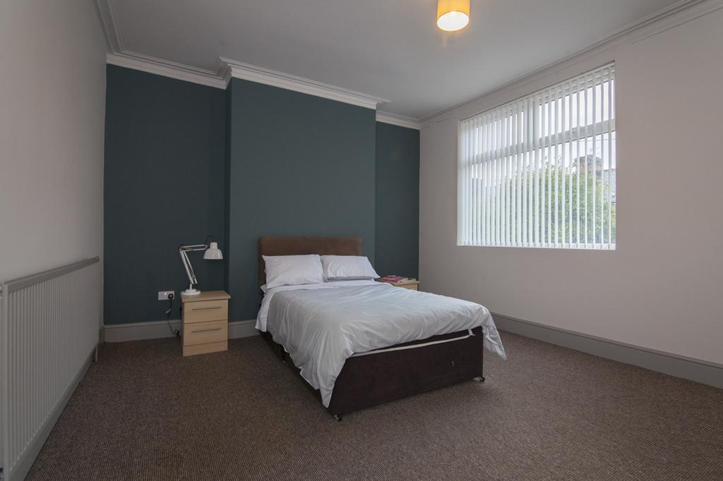 A spacious and inviting double bedroom with goo...