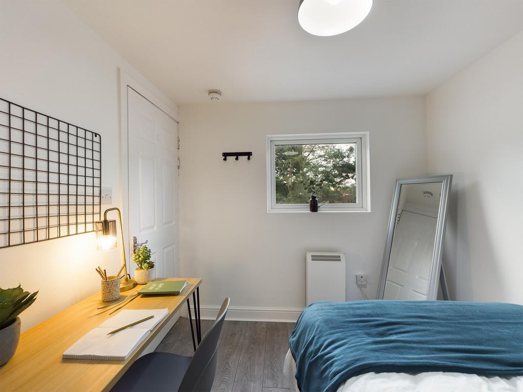 A bright and tidy double bedroom featuring a co...