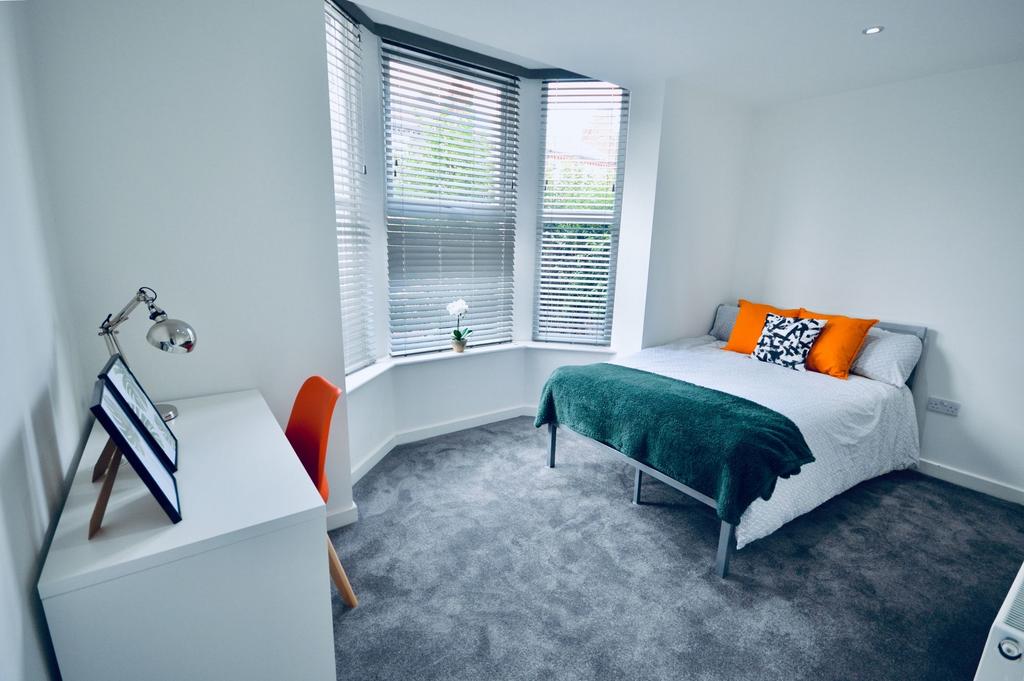A bright and modern bedroom featuring a large b...