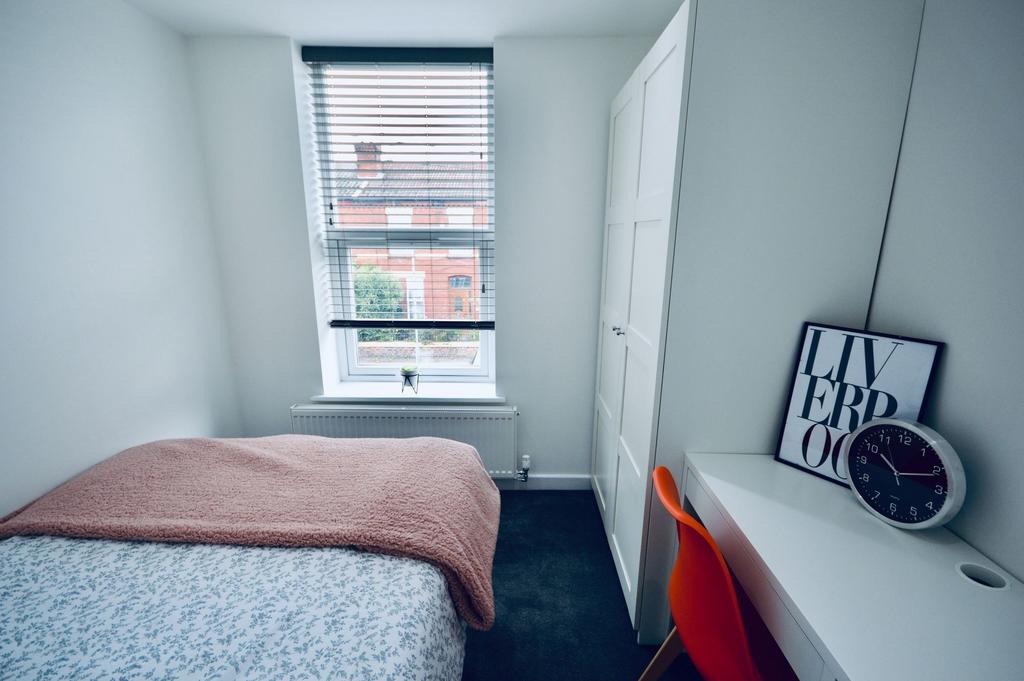 A bright, minimalist bedroom featuring a comfor...