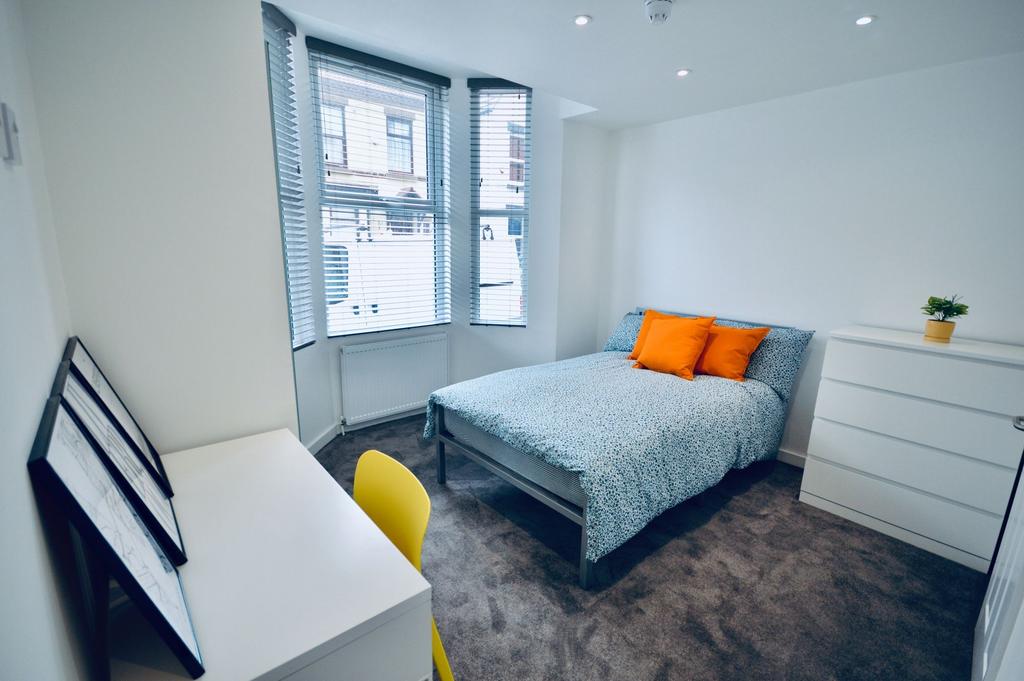 Bright and tidy bedroom with a double bed dress...