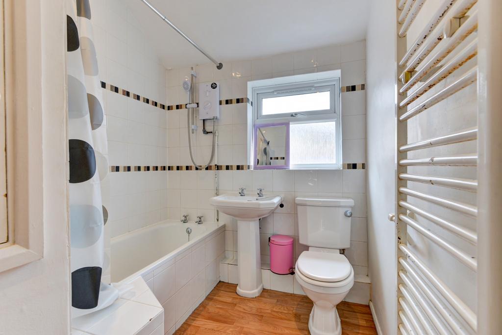 Bright and clean bathroom featuring a bathtub, ...