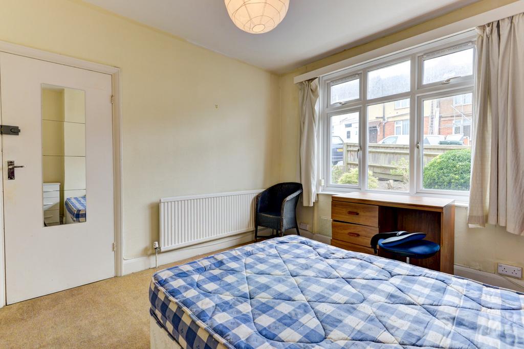 A well-lit double bedroom featuring a large win...