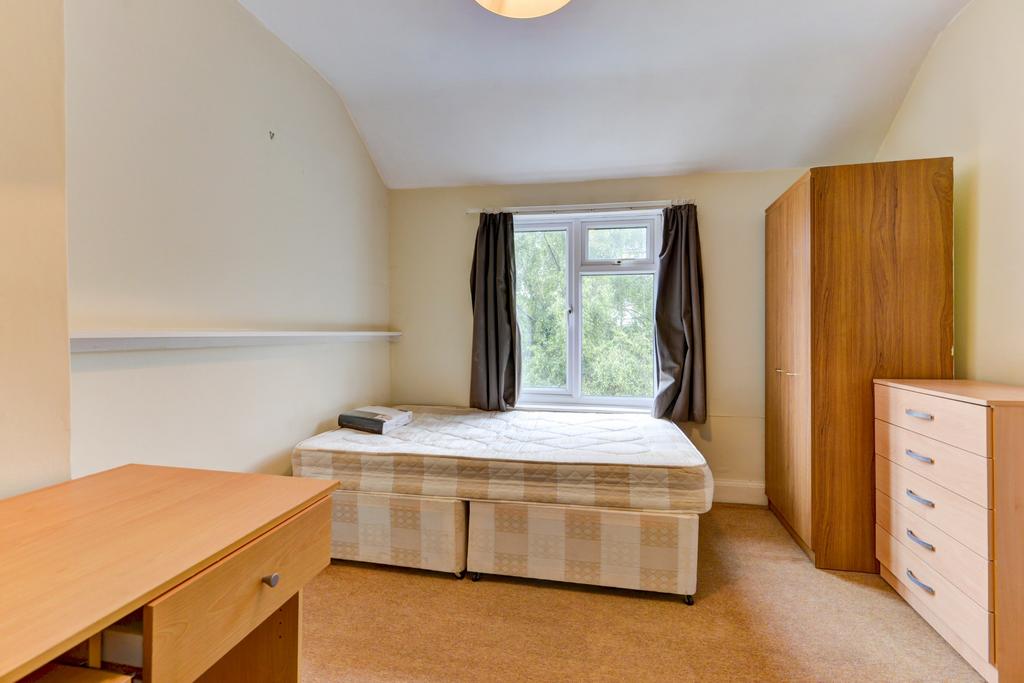 A cozy single bedroom featuring a comfortable b...