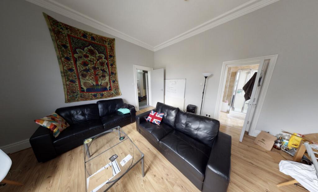 A spacious and well-lit living room featuring a...