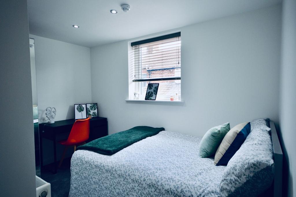 A bright and cozy bedroom featuring a double be...