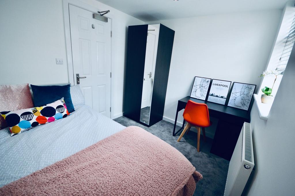 A cozy bedroom featuring a neatly made bed with...