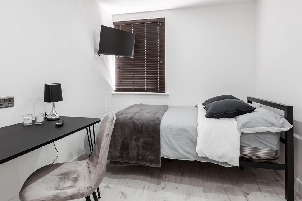 Modern double bedroom with a large bed, dark ac...