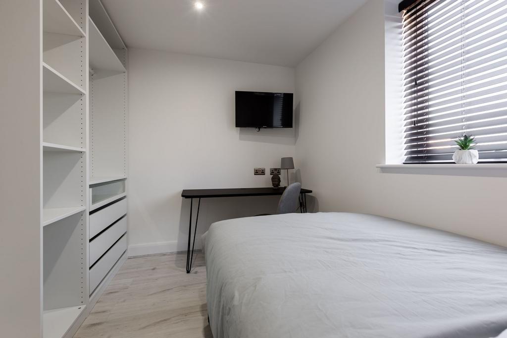 A clean and modern student bedroom featuring a ...