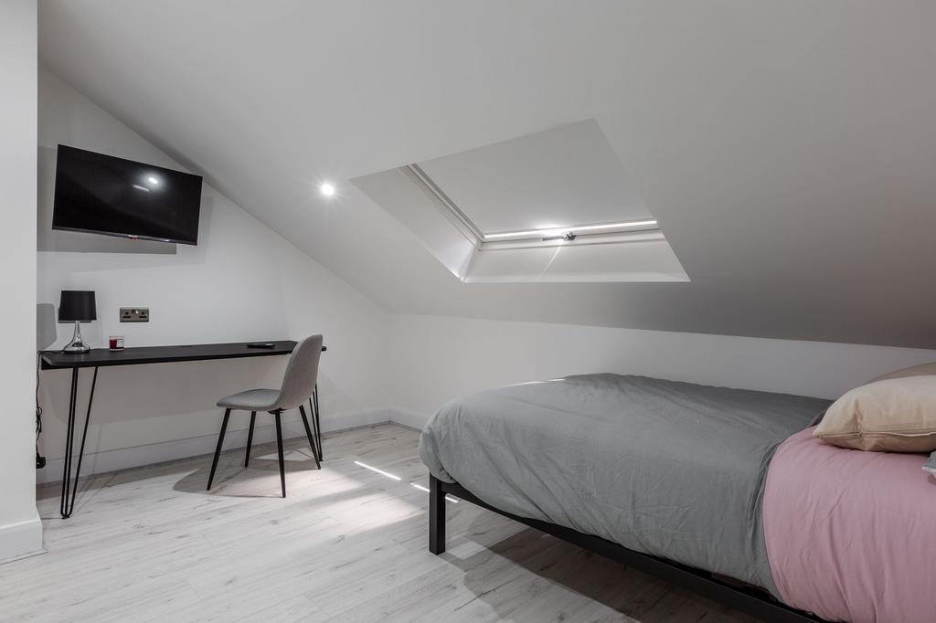 Modern, well-lit bedroom featuring a comfortabl...